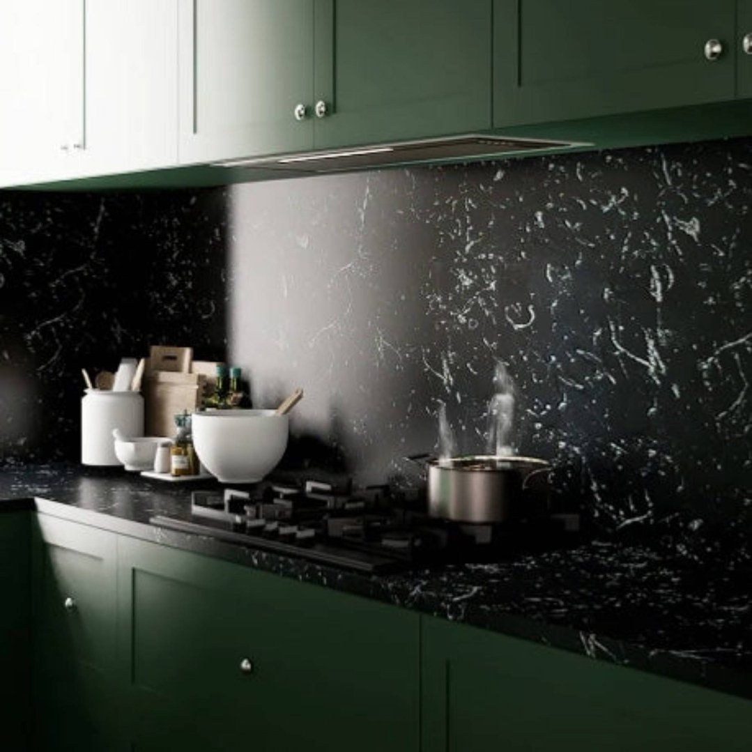 Undermount rangehood in a dark green kitchen with a black marble backsplash