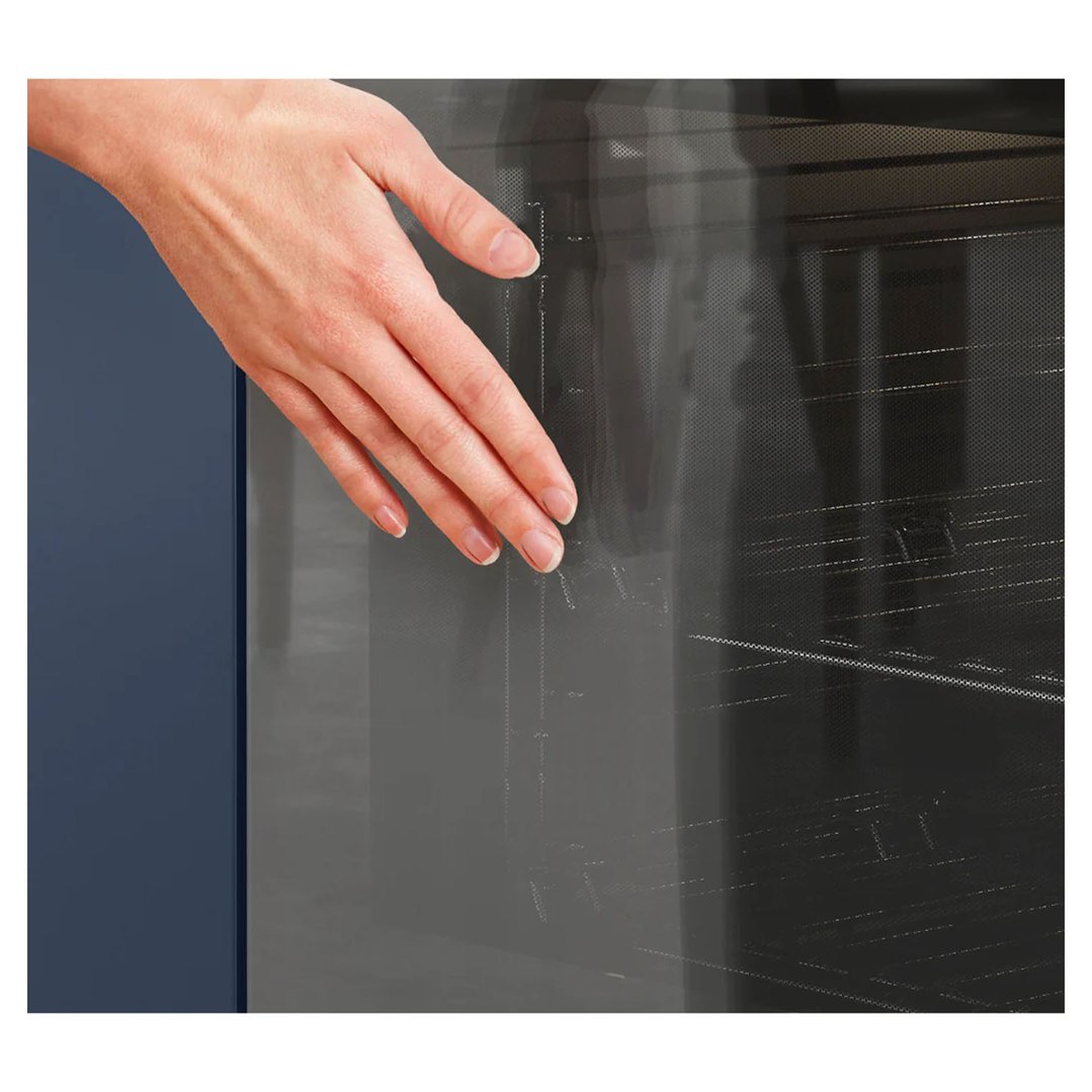 A hand touching the glass door of a built-in oven