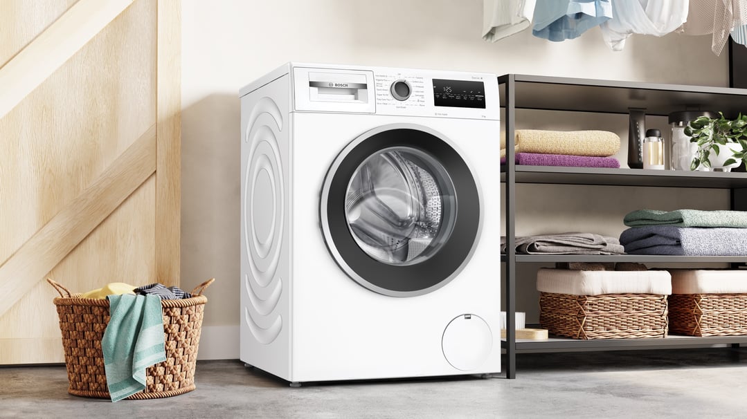 White Bosch front loader washing machine in a laundry room with a laundry basket