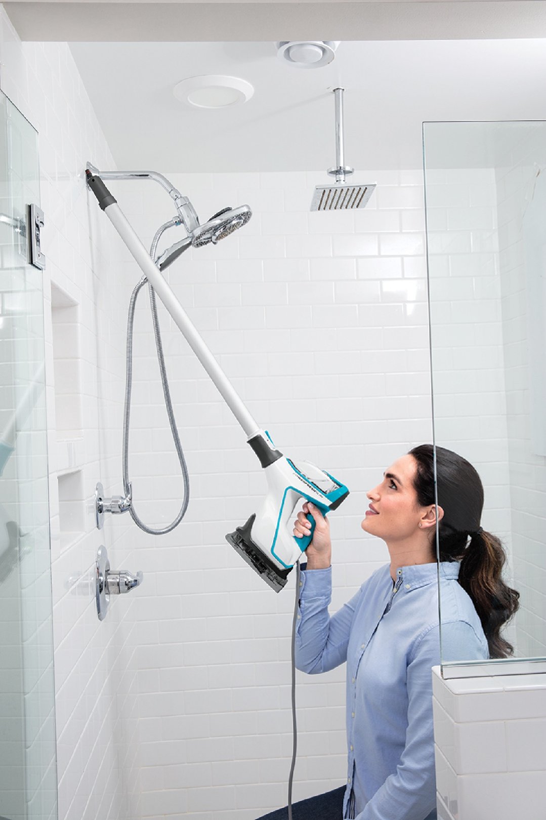 Woman cleaning a shower wall with a BISSELL PowerFresh Slim Steam Mop