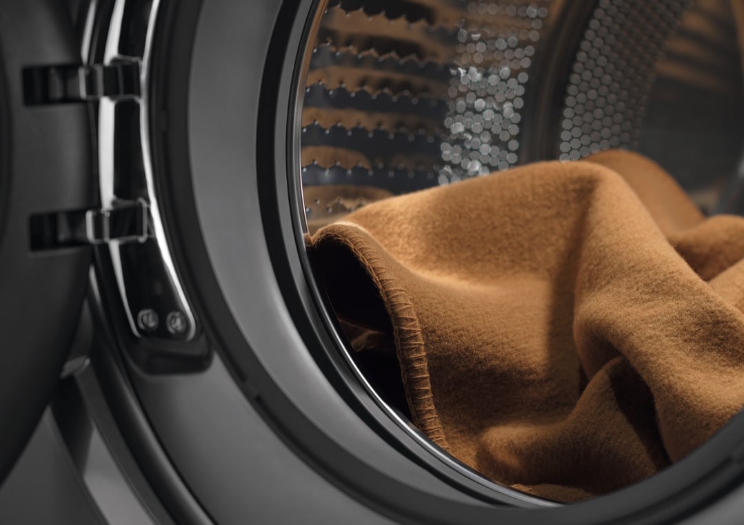 Close up of a brown blanket inside a front loader washer dryer combo