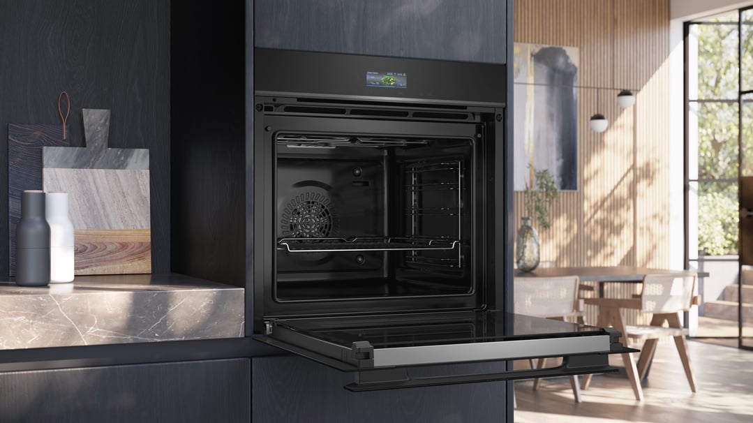 Built-in black oven with door open in a modern kitchen setting
