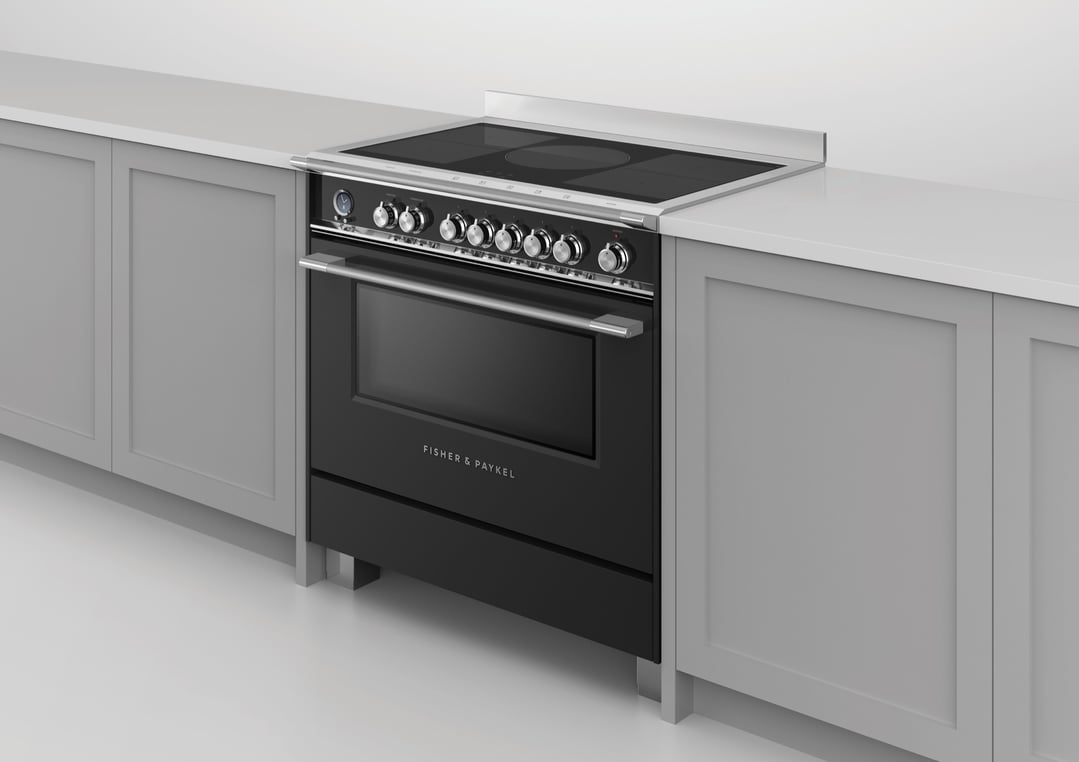 Black induction cooker with oven built into light grey kitchen cabinetry