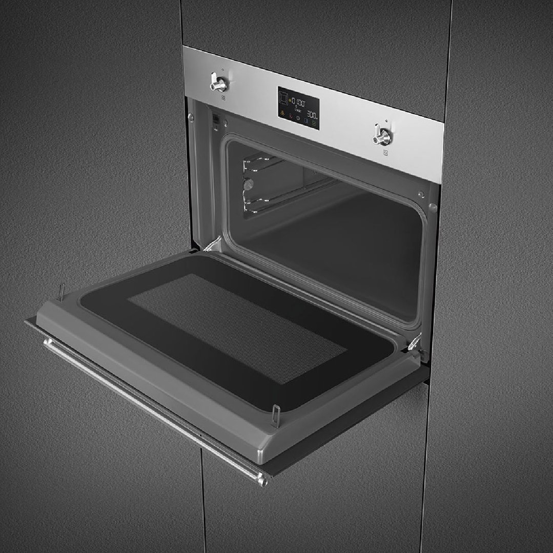 Built-in SMEG compact classic speed oven with door open in a dark kitchen