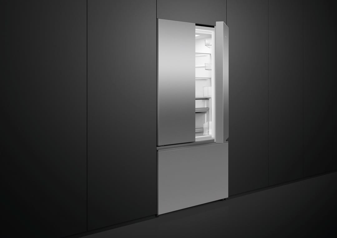 Stainless steel French door refrigerator with one door open in a dark kitchen
