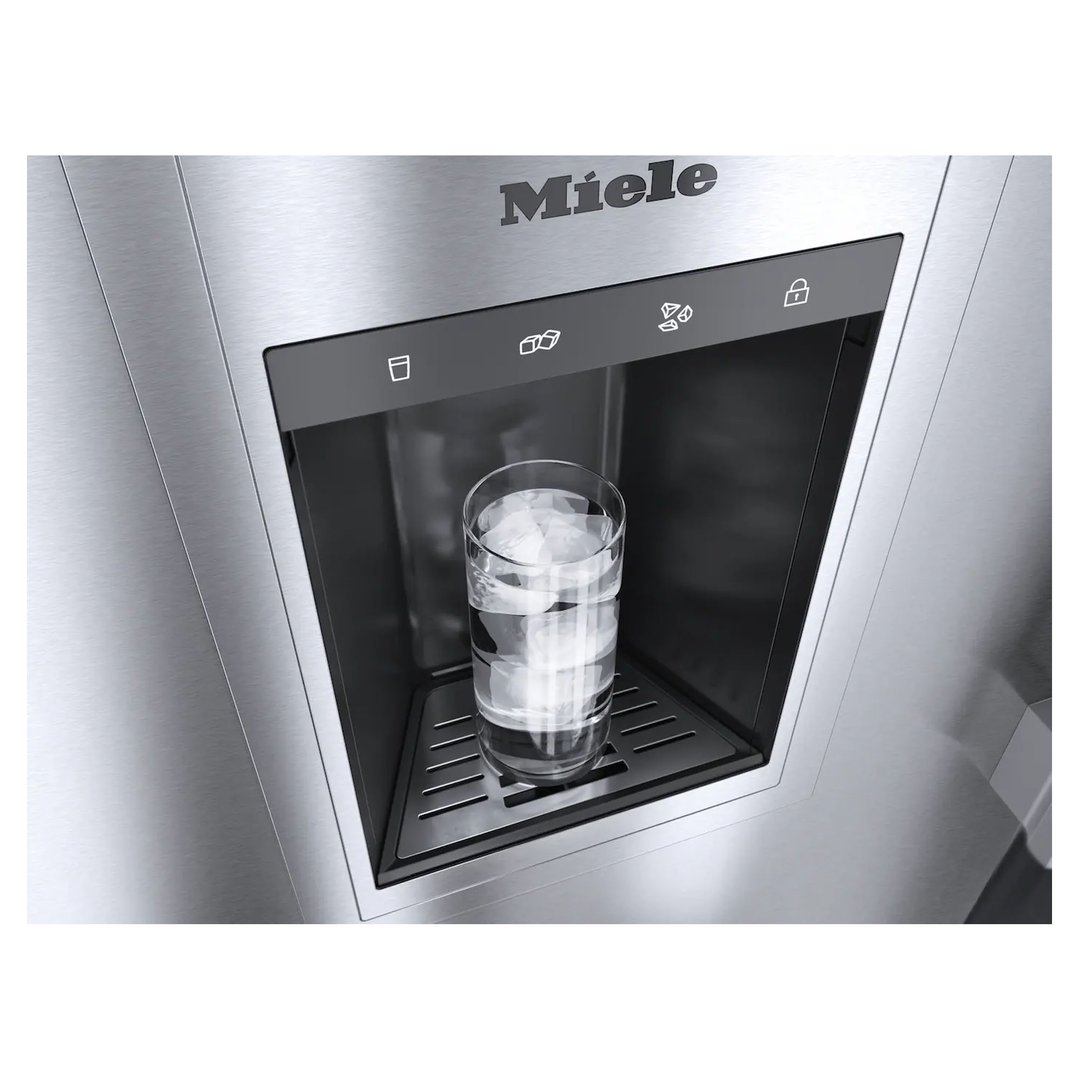 Close up of a freezer's ice and water dispenser with a glass of ice water