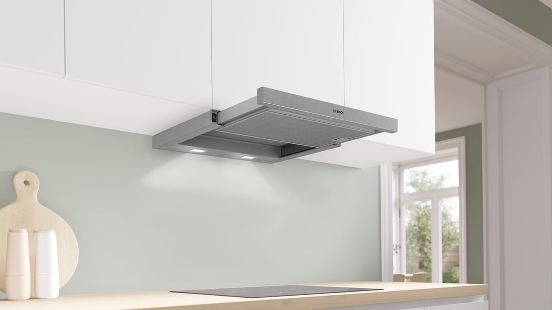 A silver metallic Bosch slideout rangehood installed above an induction cooktop in a kitchen