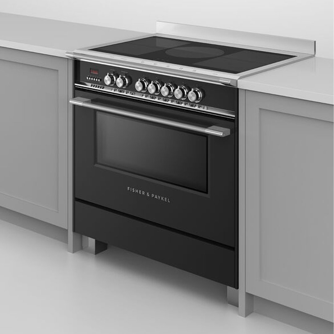 Black induction cooker with silver controls built into a light grey kitchen cabinet