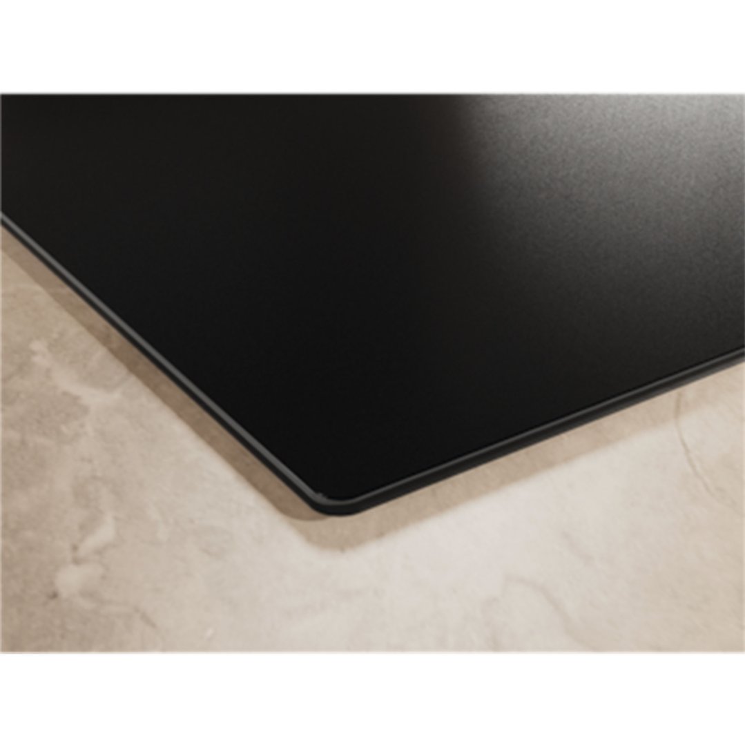 Close up of a black induction cooktop on a light-colored countertop