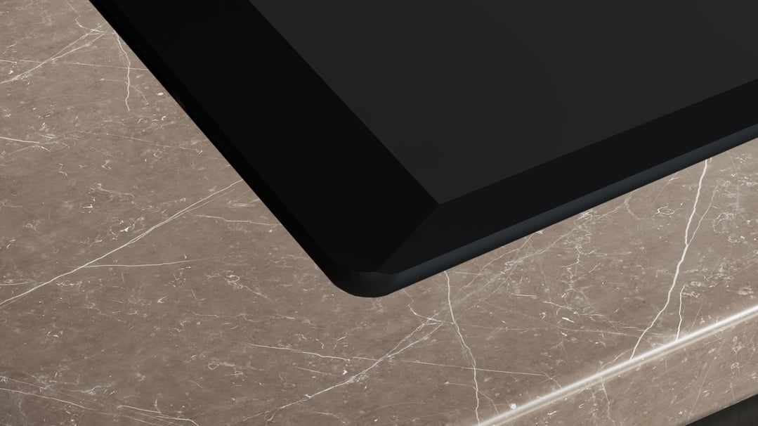 Close up of a gas cooktop on a marble countertop