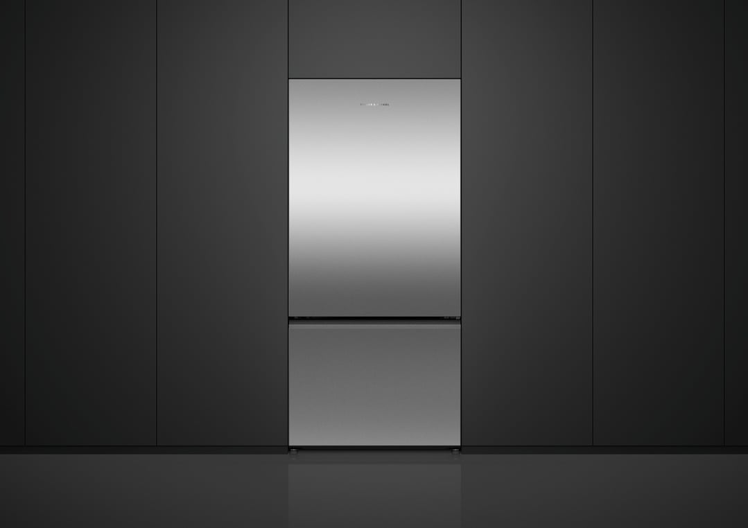 Stainless steel bottom mount fridge in a dark kitchen setting