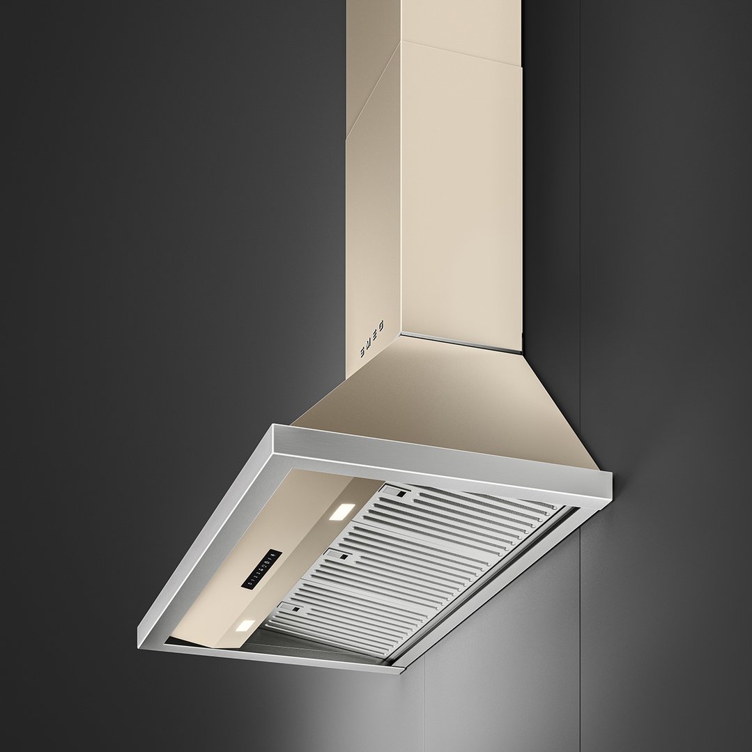 A champagne-colored rangehood with a stainless steel trim mounted on a dark wall