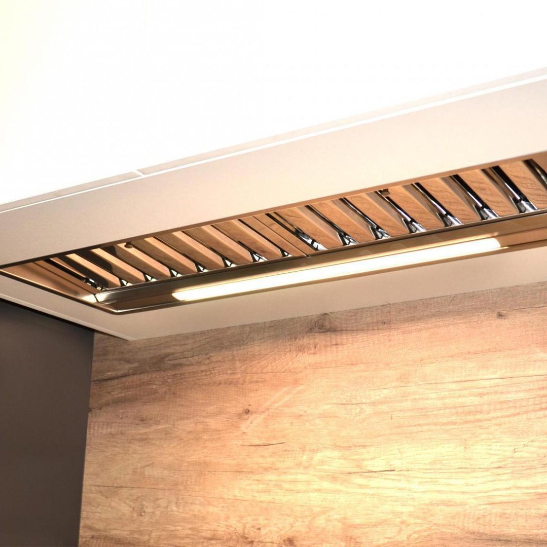 Undermount rangehood with lights illuminating a wooden kitchen wall