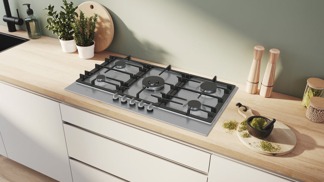 Gas cooktop integrated into a wooden kitchen countertop with various kitchen items