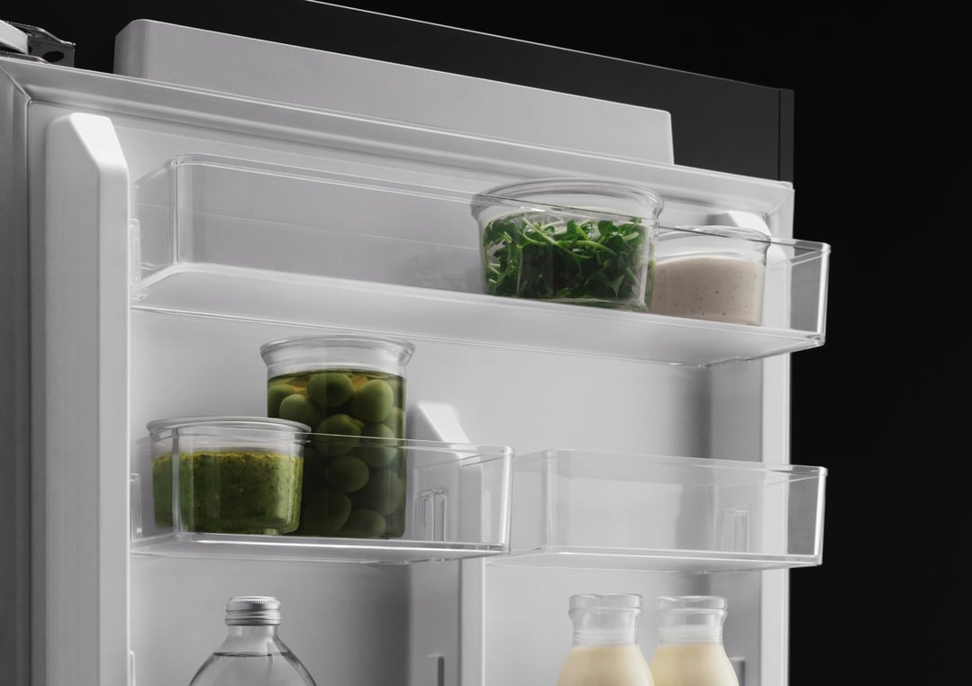 Close up of the interior of a refrigerator with food items on shelves