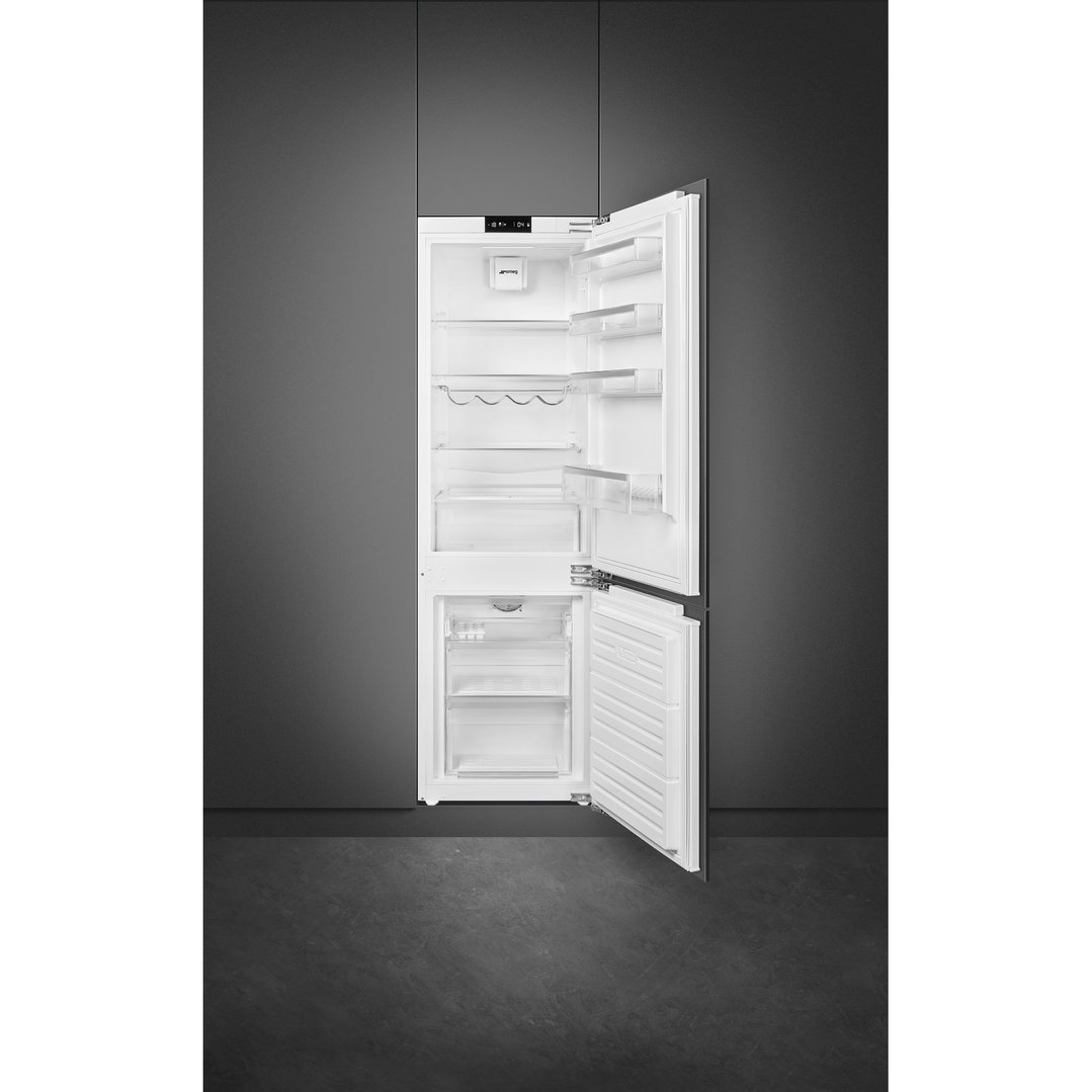 Integrated refrigerator and freezer with open doors in a dark grey kitchen