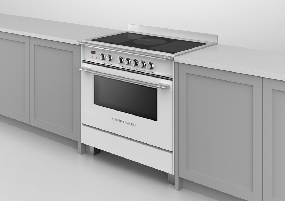 White induction cooker with oven in a kitchen with grey cabinets and white countertop