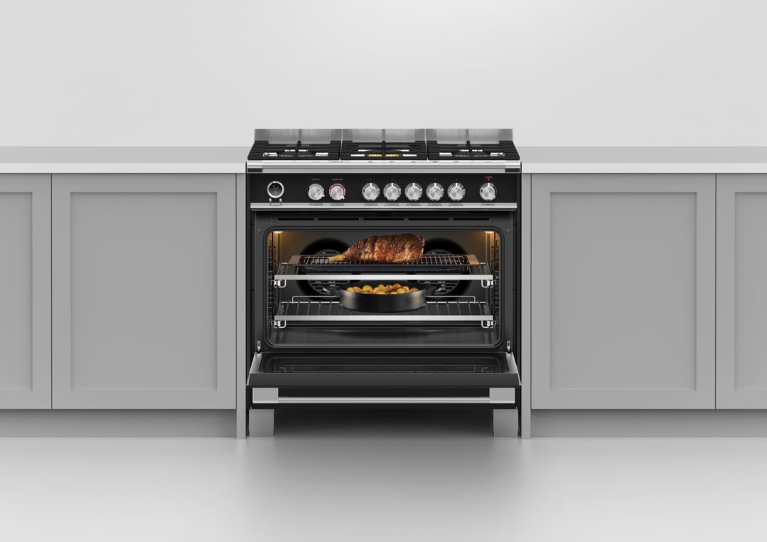 Freestanding dual fuel cooker with an open oven door in a kitchen setting