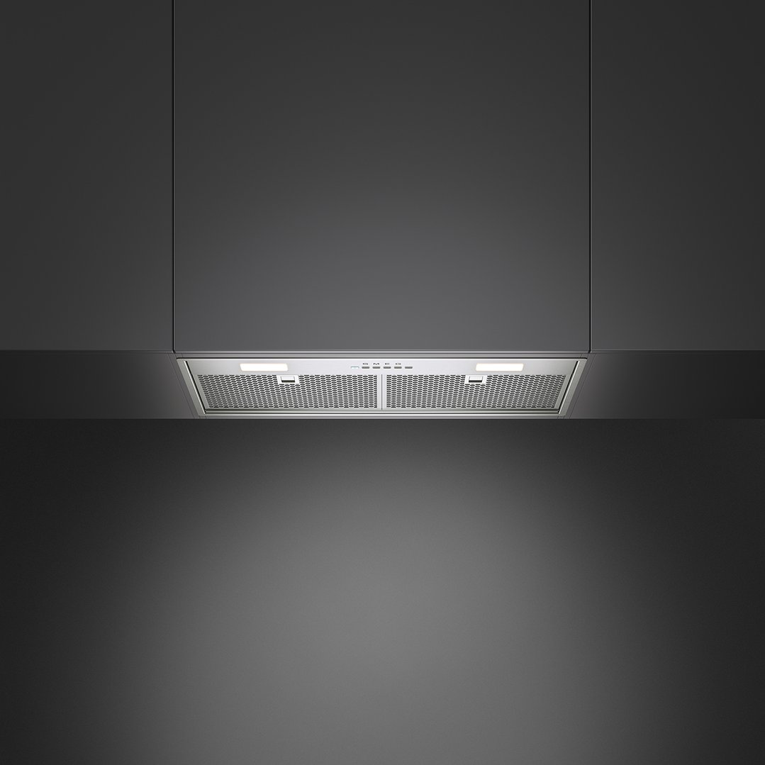 Stainless steel rangehood with lights on, installed under dark kitchen cabinets