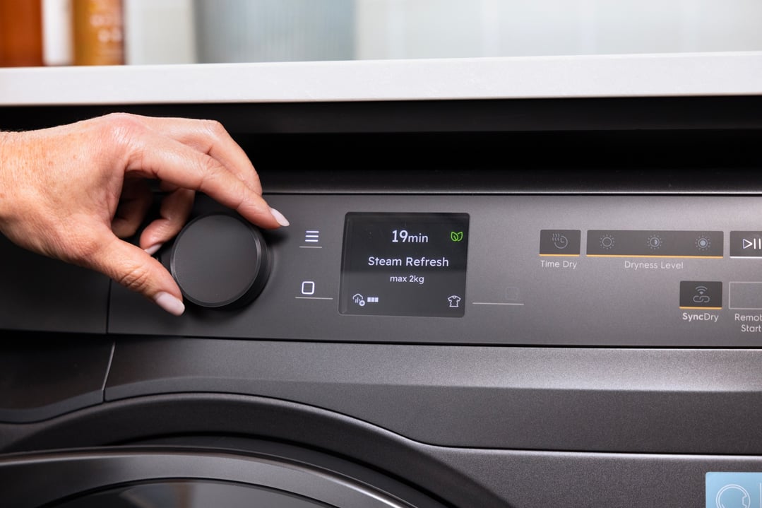 Woman's hand adjusting the dial on a dark onyx heat pump dryer