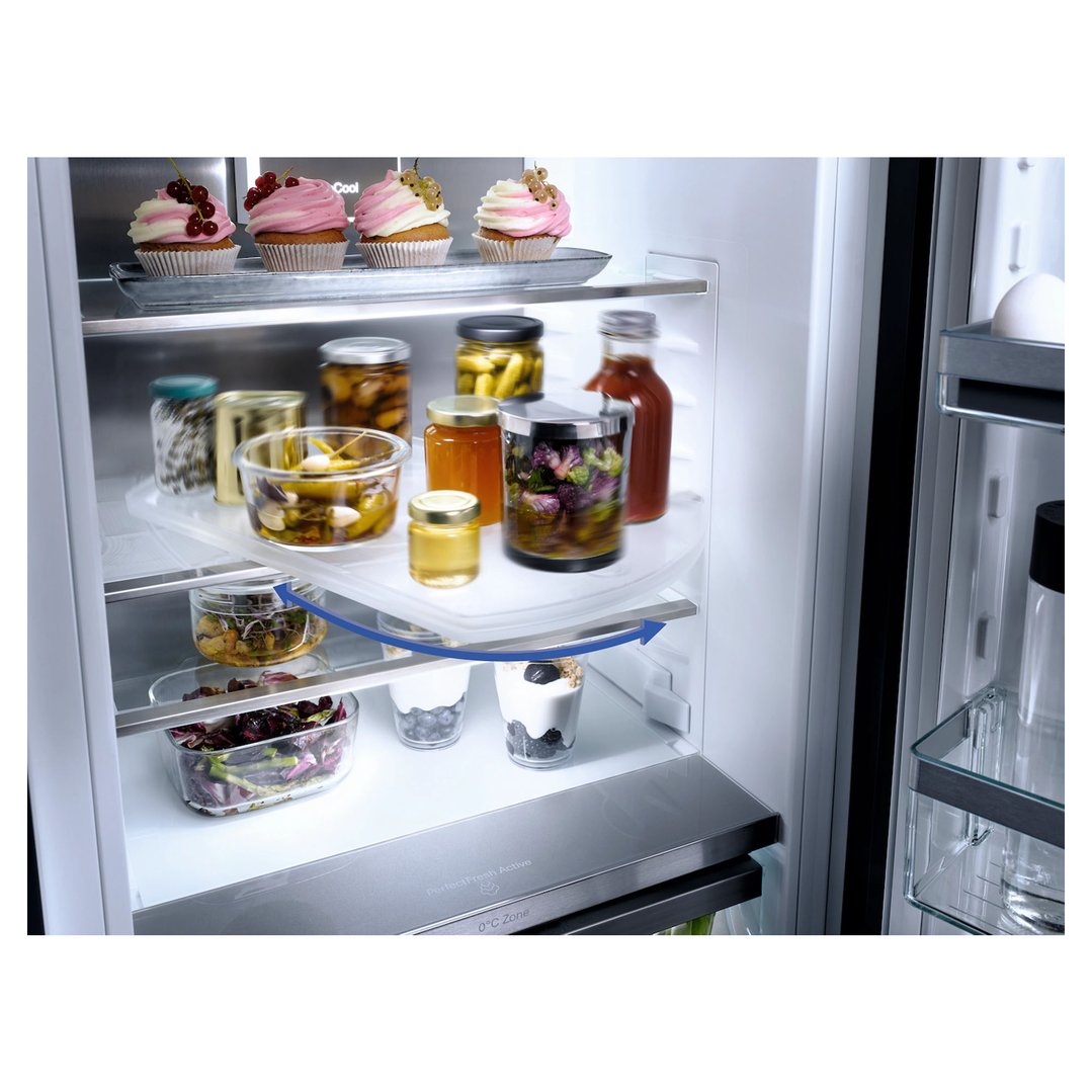 Open integrated fridge with food items and a rotating shelf feature