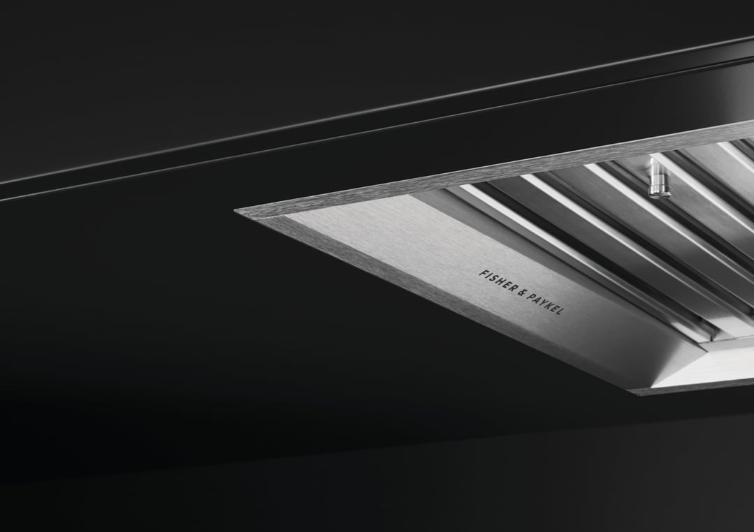 Close up of a Fisher & Paykel integrated insert wall rangehood in a dark kitchen