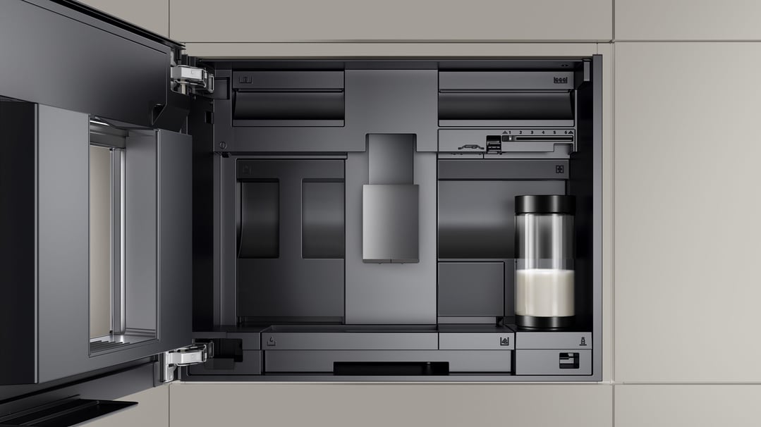 Built-in coffee machine with door open, showing internal components and milk container