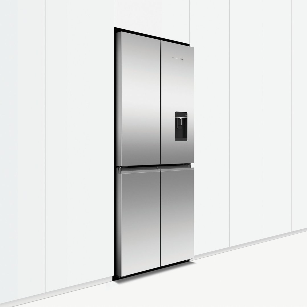 Stainless steel quad door refrigerator freezer with ice and water dispenser in a kitchen