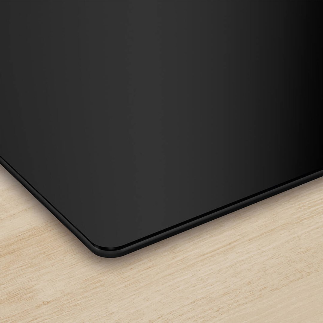 Close-up of a black Bosch induction cooktop on a light wooden countertop