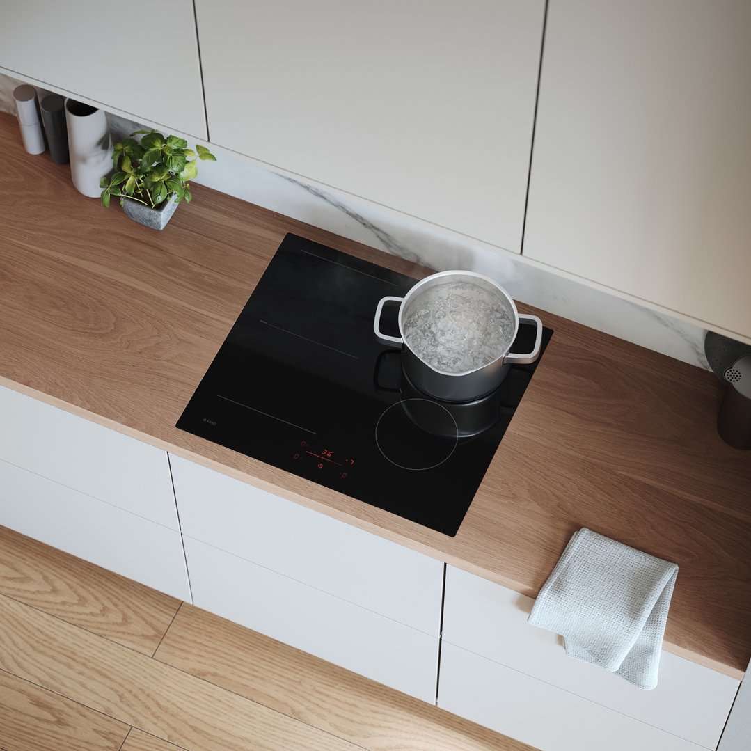 Overhead view of a black induction cooktop with a pot of boiling water