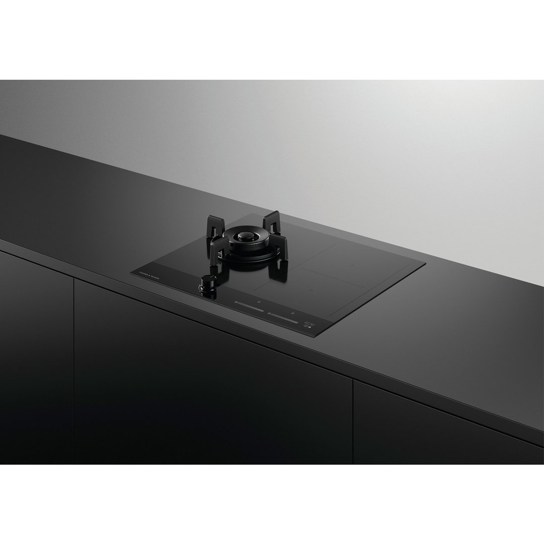 Black hybrid cooktop with gas burner and induction zones in a modern kitchen