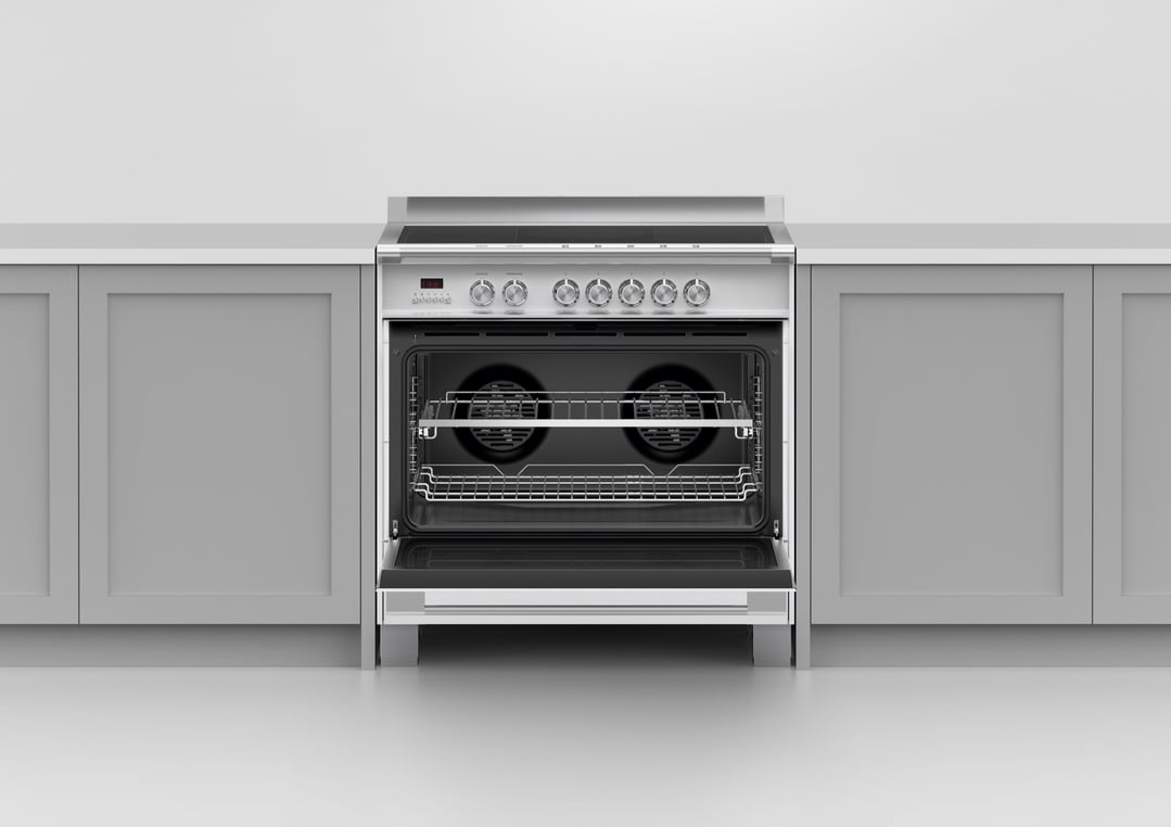 Stainless steel oven with open door, showing interior racks, in a kitchen setting