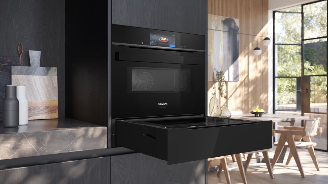 Built-in oven and warming drawer in a modern kitchen with dining area
