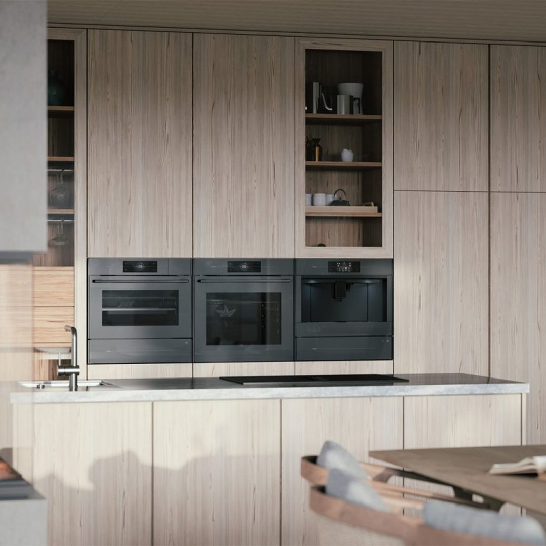 Built-in coffee machine and two ovens in a modern kitchen with light wood cabinetry