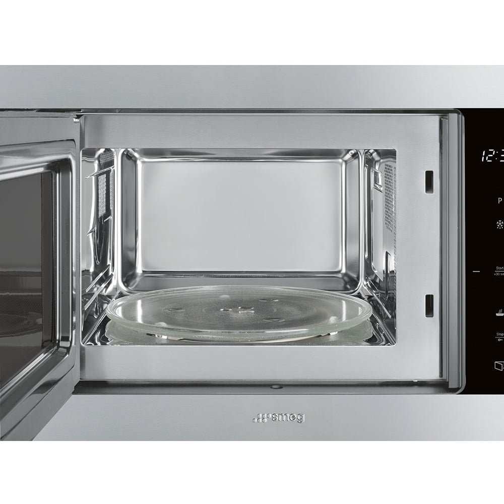 Open built-in microwave with a glass turntable inside