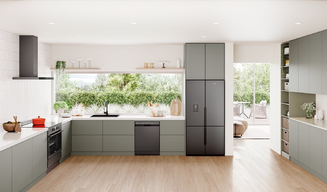 A matte charcoal black quad door fridge in a modern kitchen with light green cabinets