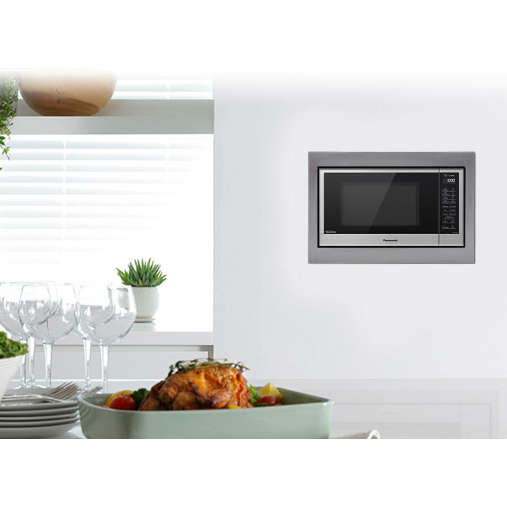 Microwave trim kit built into a white wall in a modern kitchen setting