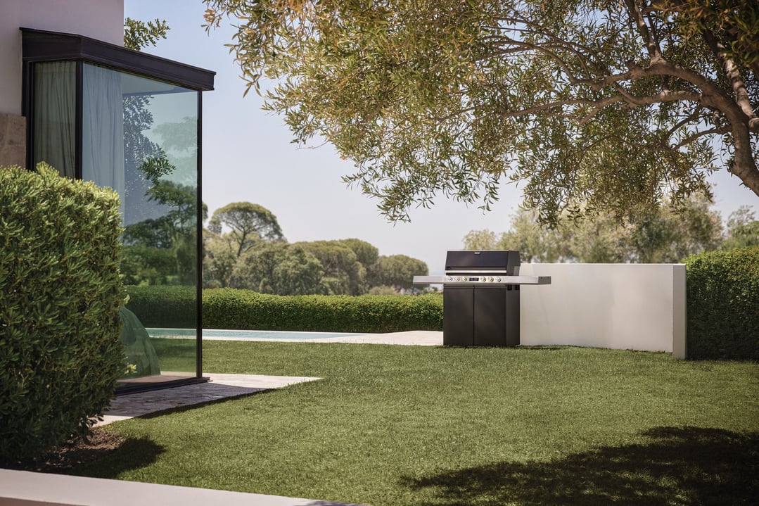 Barbeque module in an outdoor setting with a lawn and trees