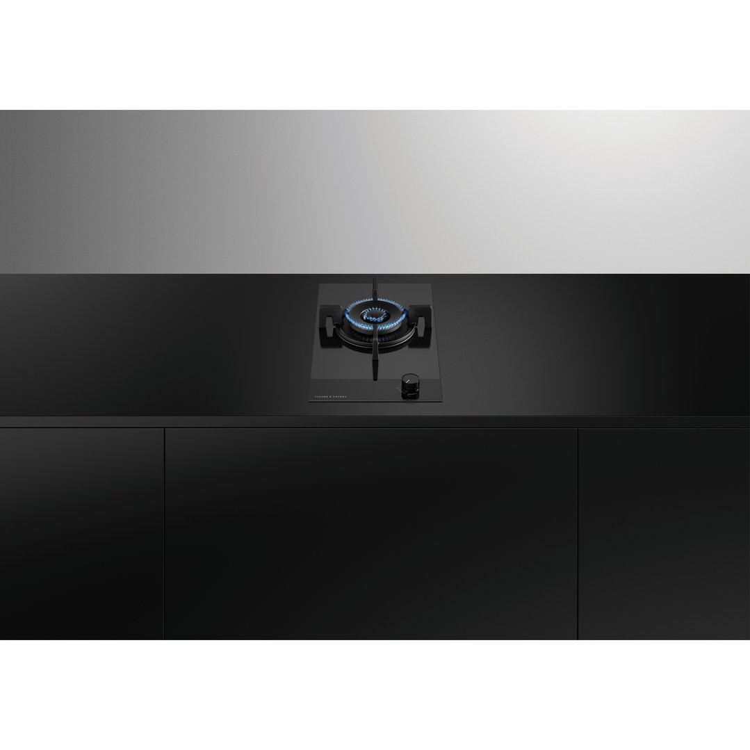 Black gas on glass cooktop with blue flame in a modern kitchen