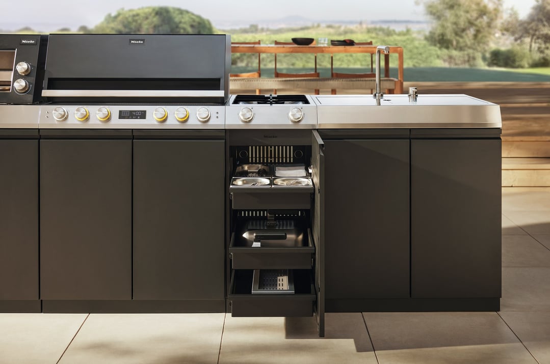 Outdoor cooking module with drawers and sink in an outdoor kitchen setting
