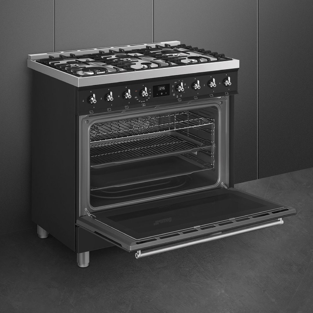 Freestanding oven with open door in a dark kitchen setting