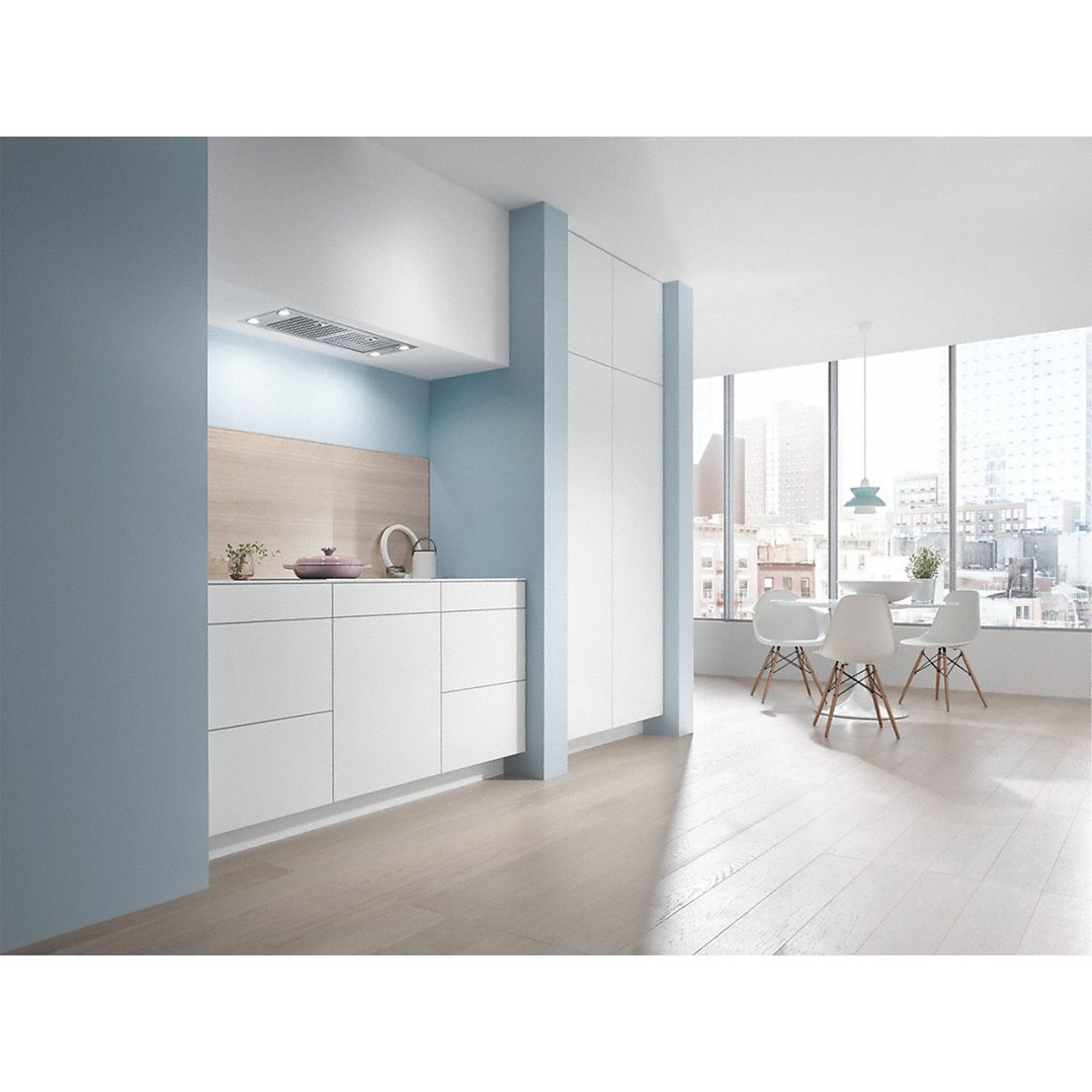 Built-in rangehood in a modern kitchen with light blue walls and dining area