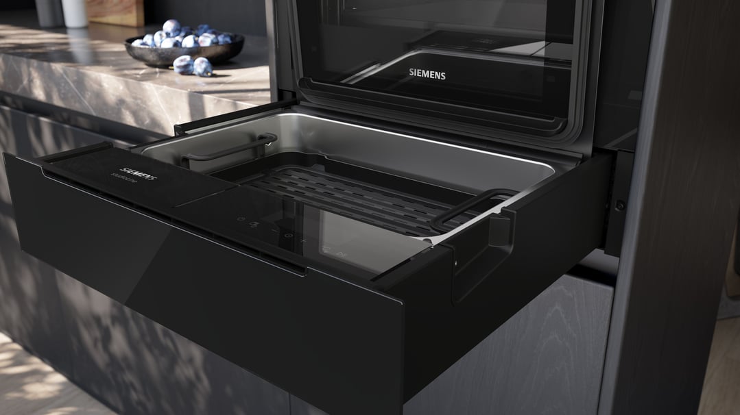 Open Siemens steam drawer in a modern kitchen setting with a bowl of fruit