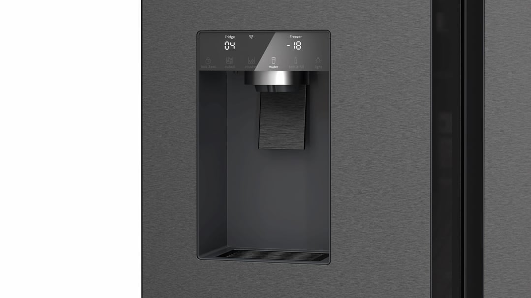 Close up of the water and ice dispenser on a black steel fridge freezer