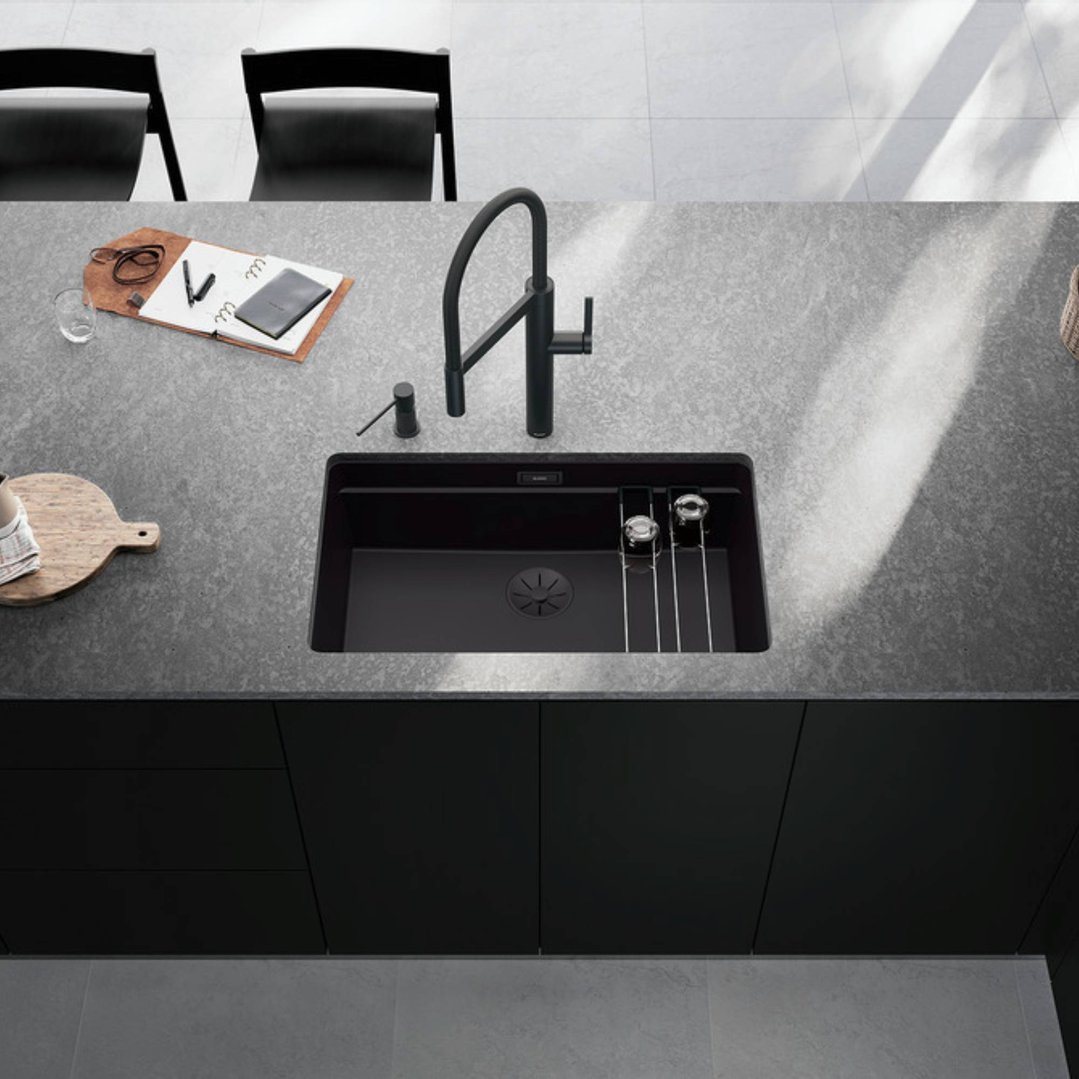 Black matte mixer tap installed in a kitchen sink with a grey countertop