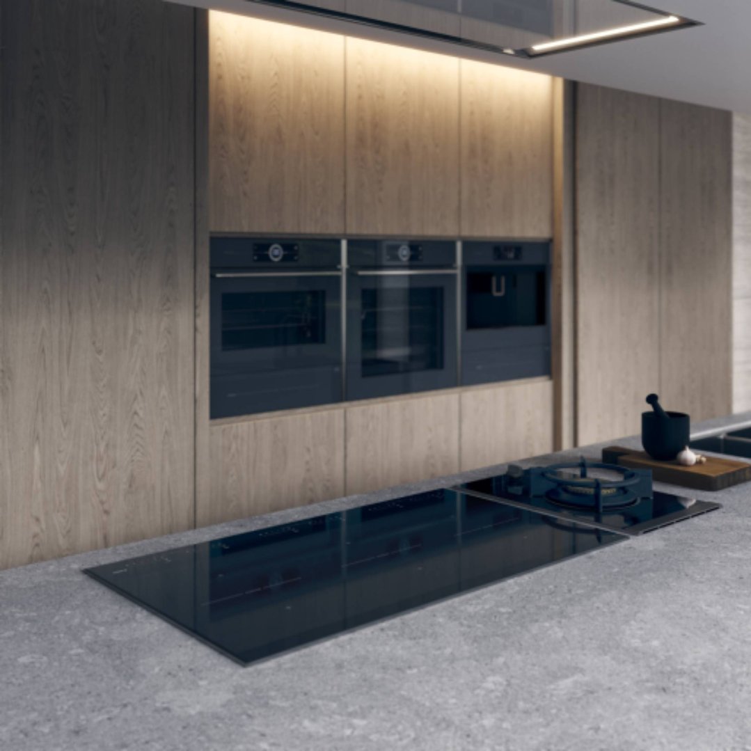 Three built-in ovens and a built-in coffee machine in a modern kitchen setting