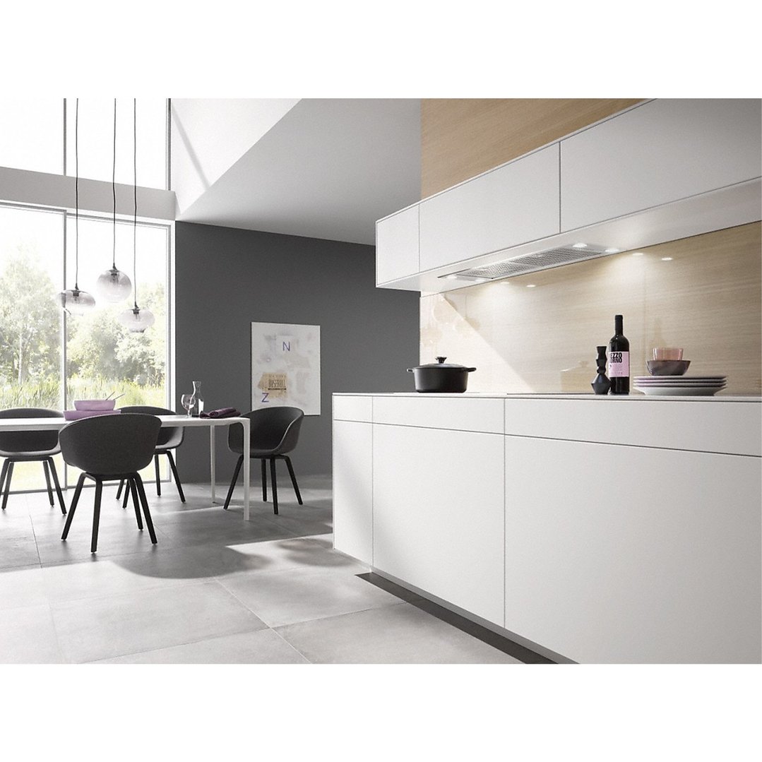 Built-in rangehood in a modern kitchen with dining area and large windows