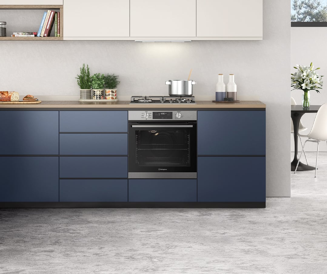 Built-in oven and gas cooktop in a modern kitchen with blue cabinets