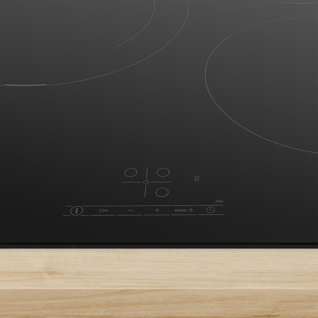 Black induction cooktop with controls on a light wooden countertop