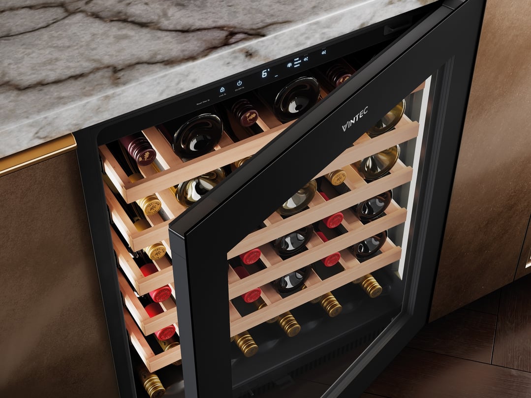 Open Vintec wine cabinet with bottles on wooden shelves built into a kitchen counter